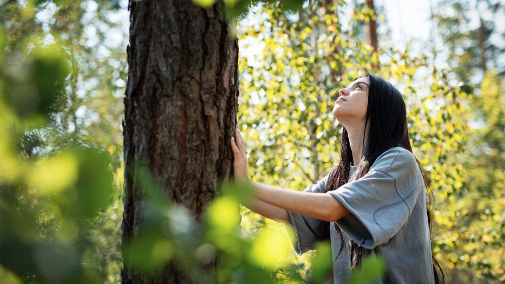 Mujer abraza un árbol.