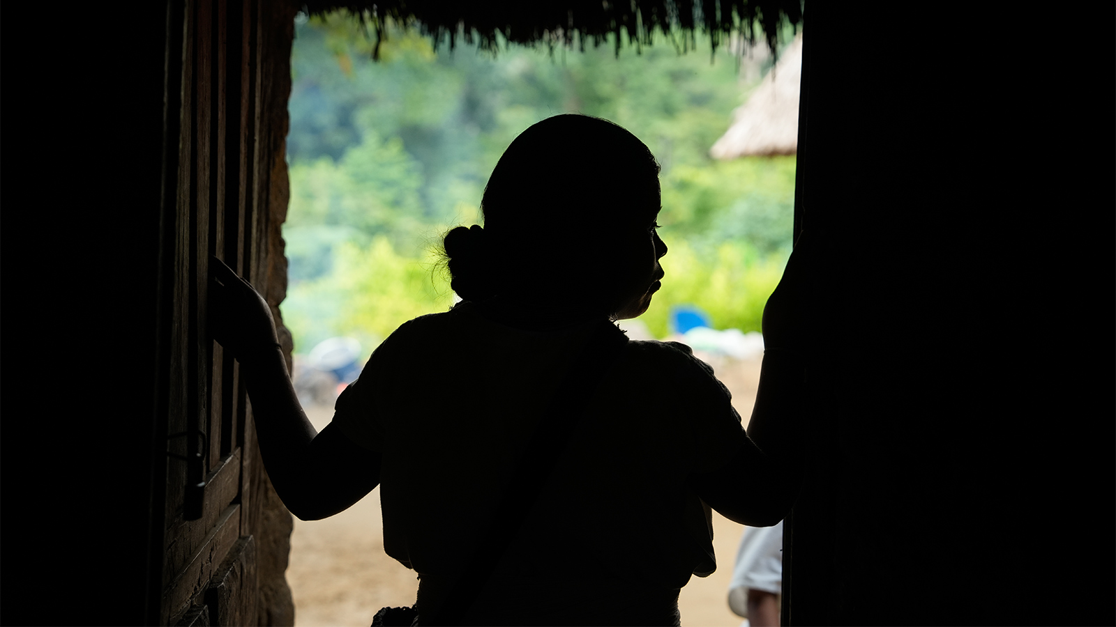 fotografía a contra luz de una mujer de la Sierra Nevada de Santa Marta, en la puerta de su casa