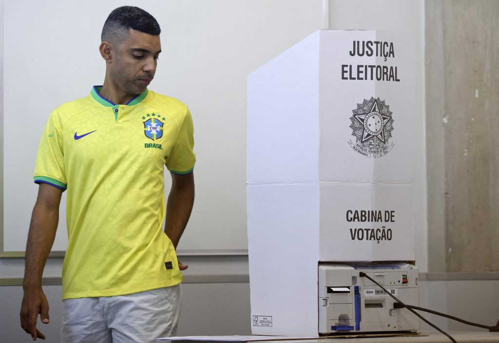 Un votante que lleva la camiseta de la selección nacional de fútbol de Brasil ejerce su derecho al voto durante las elecciones presidenciales en un centro de votación de Brasilia, el 4 de octubre de 2026.
